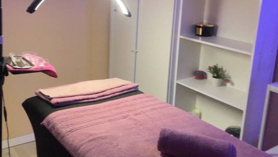 Sala de masajes en DB Beauty, Madrid, Comunidad De Madrid, ES con toallas rosadas y ambiente acogedor.