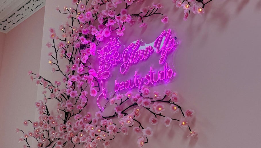 Pink neon sign 'Glow Up Beauty Studio' with cherry blossoms in Dublin, County Dublin, IE.
