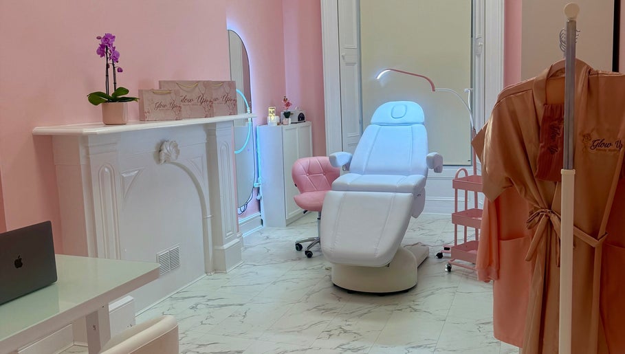 Elegant treatment room at Glow Up Beauty Studio, Dublin, County Dublin, IE, with pink walls and plush seating.