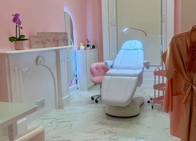 Elegant treatment room at Glow Up Beauty Studio, Dublin, County Dublin, IE, with pink walls and plush seating.