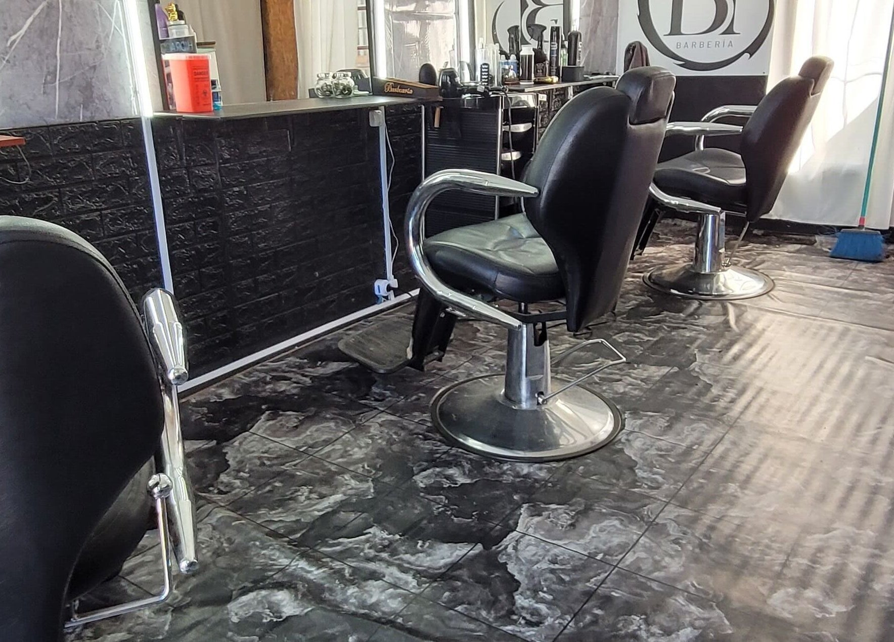 Interior de BT BARBERÍA, Salinas, Departamento De Canelones, UY, con sillas negras y pisos modernos.