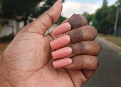 Coral manicured nails seen at Leko Nails, Midrand, Gauteng, ZA, showcasing precision and style.