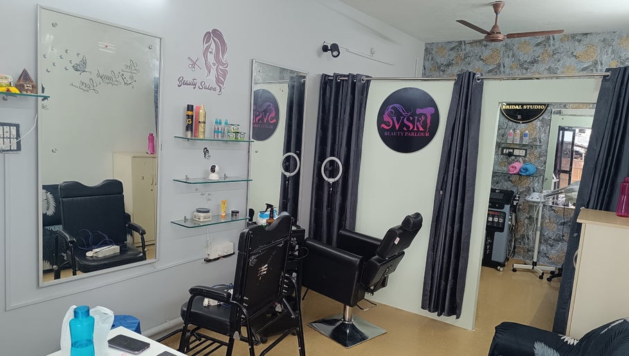 Modern interior of VSK Beauty Parlour in Puducherry, featuring styling chairs, mirrors, and floral decor.