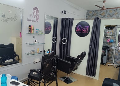 Modern interior of VSK Beauty Parlour in Puducherry, featuring styling chairs, mirrors, and floral decor.