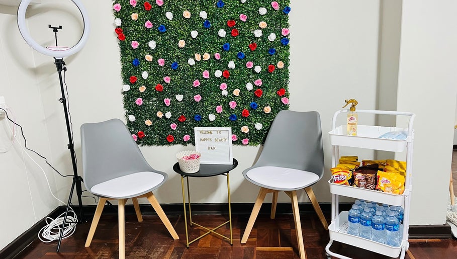 Seating area with floral wall at Happy’s Beauty Bar, Pretoria, Gauteng, ZA.