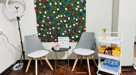 Seating area with floral wall at Happy’s Beauty Bar, Pretoria, Gauteng, ZA.