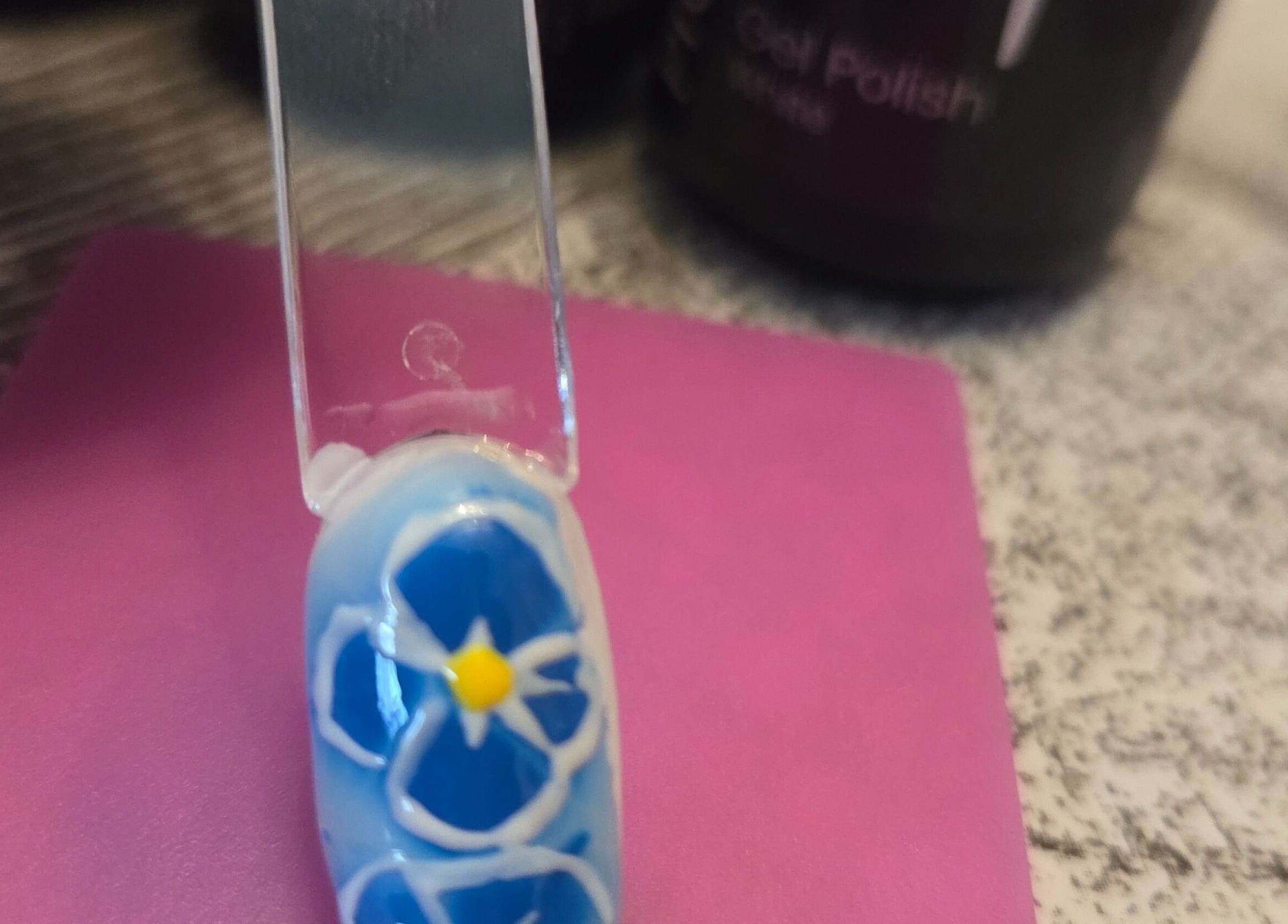 Un ongle décoré d'une fleur bleue au salon Queen nails'freda, Nœux-les-mines, Hauts-de-france, FR.