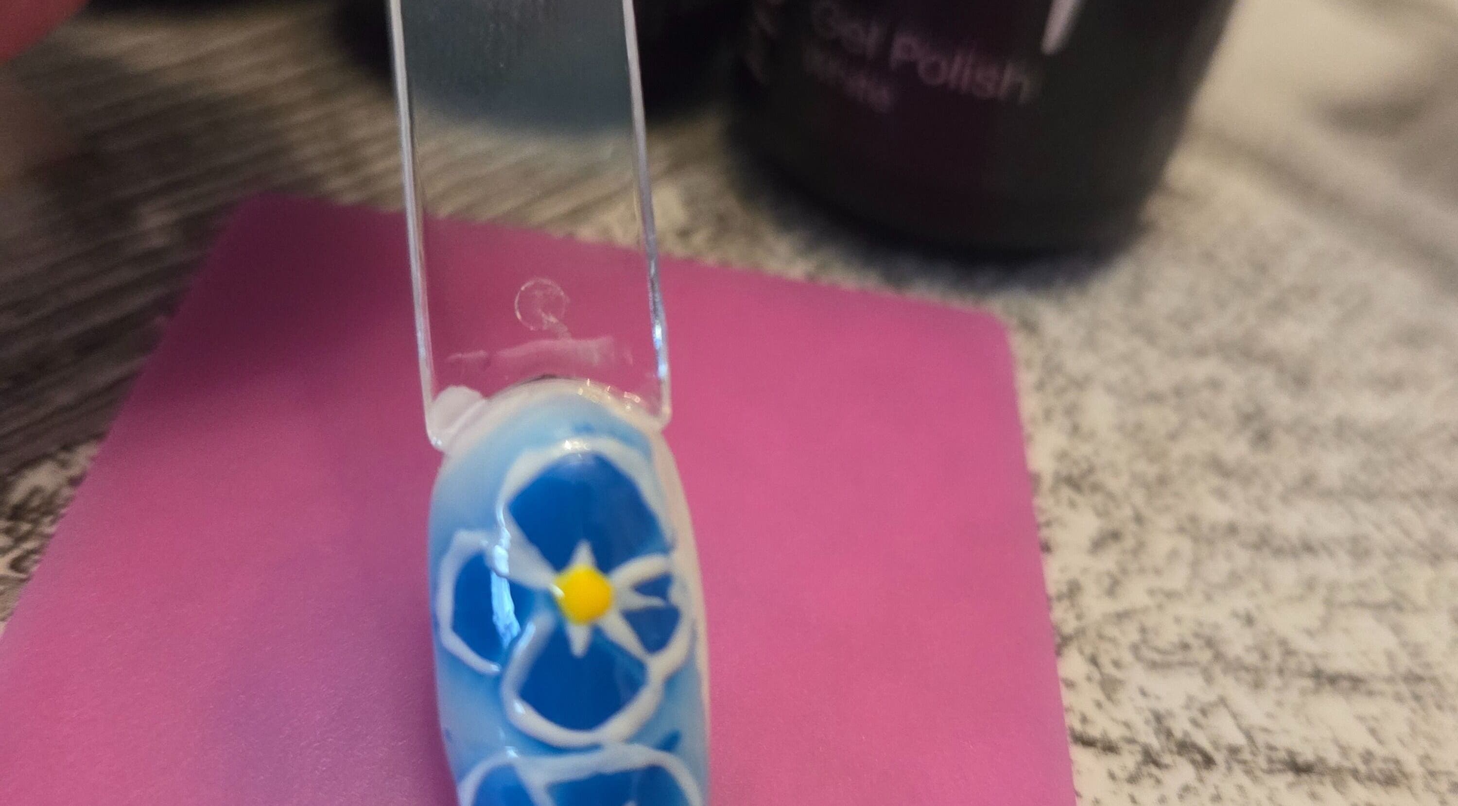 Un ongle décoré d'une fleur bleue au salon Queen nails'freda, Nœux-les-mines, Hauts-de-france, FR.