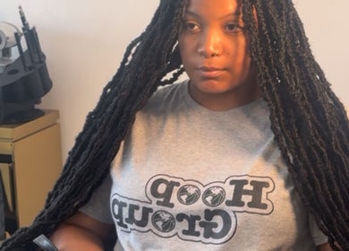 Woman with stylish long braids at Saniyah Stylez in Philadelphia, US, showcasing expert hair styling skills.