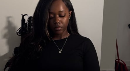 Relaxed individual with long hair at Saniyah Stylez, Philadelphia, US, highlighting calm ambiance.