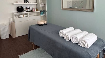 Masážní místnost v BodyCare Prague, Hlavní Město Praha, CZ s šedým prostěradlem a bílými ručníky.