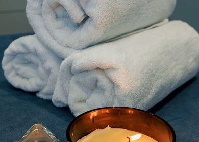 Uvolňující atmosféra s bílými ručníky a svíčkou v BodyCare Prague, Hlavní Město Praha, Hlavní Město Praha, CZ.
