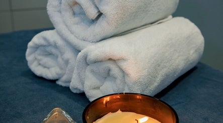 Uvolňující atmosféra s bílými ručníky a svíčkou v BodyCare Prague, Hlavní Město Praha, Hlavní Město Praha, CZ.