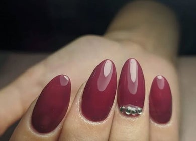 Manicura elegante en Uñitas Fashion, Lanús, Provincia De Buenos Aires, AR, con diseño bordó y pedrería.