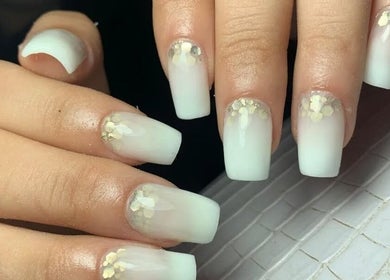 Manicura elegante en Uñitas Fashion, Lanús, Provincia De Buenos Aires, AR con diseño blanco y detalles dorados.