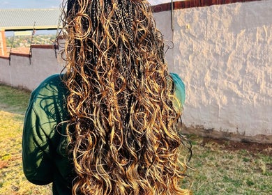 Lush, golden curls styled at Hairbylue in Midrand, Gauteng, ZA, showcasing expert hair artistry.