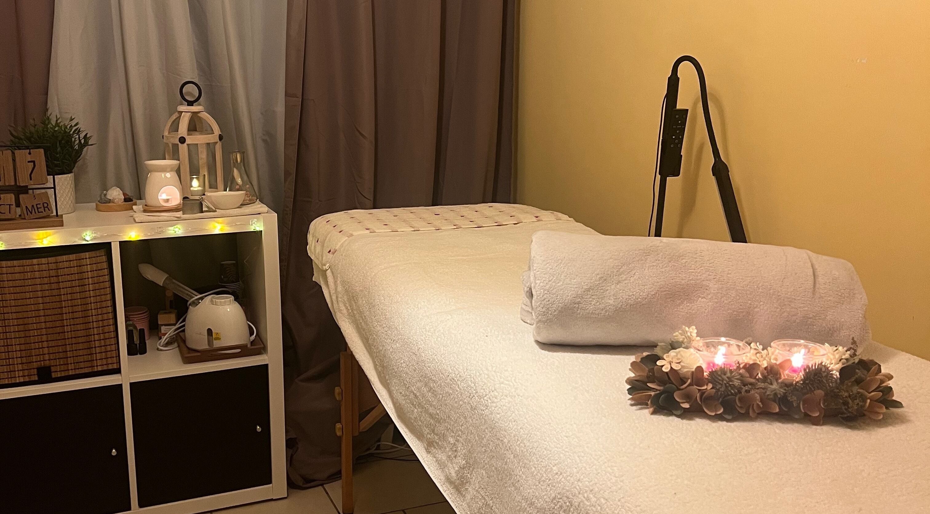 Salle de massage paisible à Bulle De Bien être, Avanton, Nouvelle-aquitaine, FR, éclairée par des bougies.