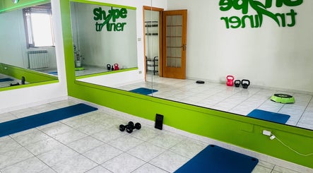 Interno della palestra Shape Trainer con specchi e attrezzi a Messina, Sicilia, IT.