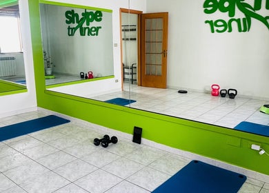 Sala fitness moderna di Shape Trainer a Messina, Sicilia, IT con attrezzature e specchi.