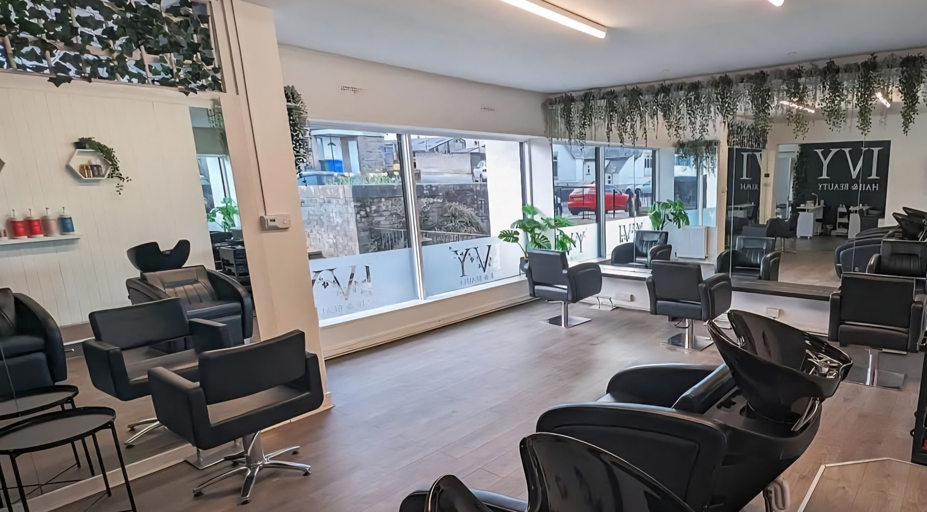 Modern salon interior at Inspired Hair Design, Uphall Station, Scotland, GB with sleek chairs and mirrors.