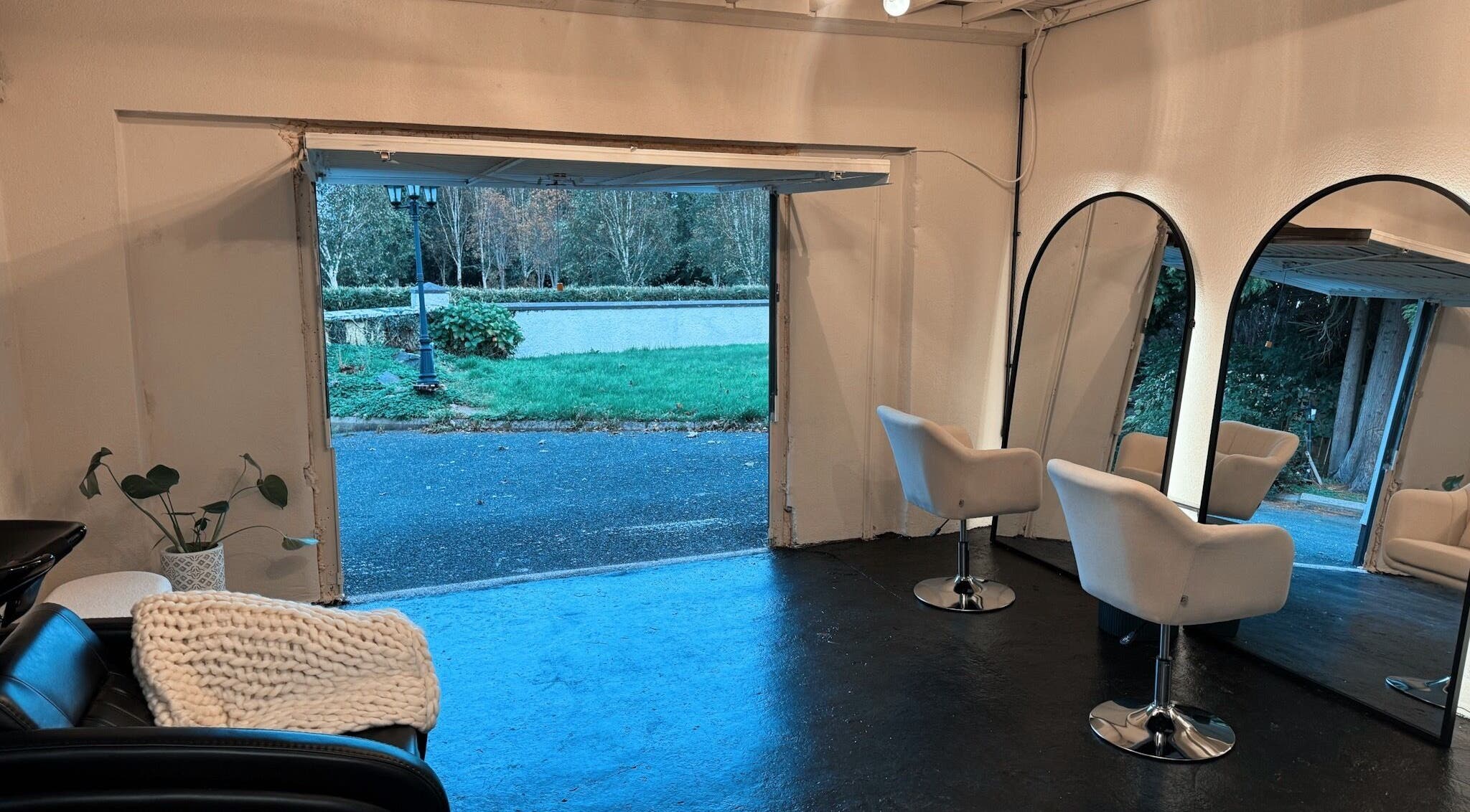Cozy interior of Salon LOTI in Newry, Northern Ireland, GB featuring white chairs and large mirrors.