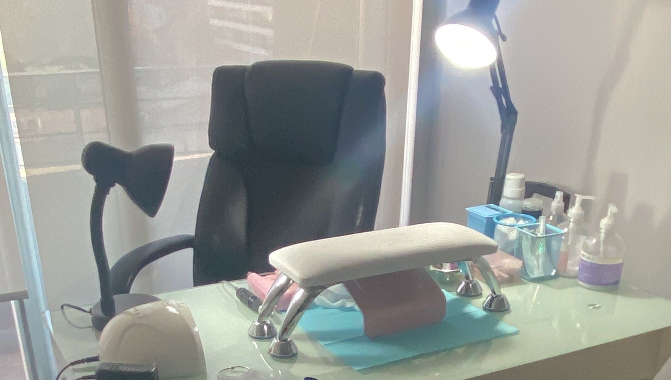 Zona de trabajo en Glowesome Nails, Santiago, Región Metropolitana, CL, con silla y mesa equipada para manicura.