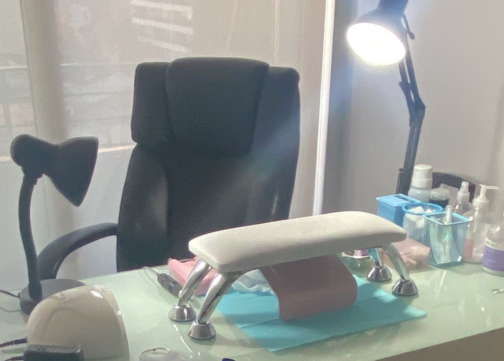 Zona de trabajo en Glowesome Nails, Santiago, Región Metropolitana, CL, con silla y mesa equipada para manicura.