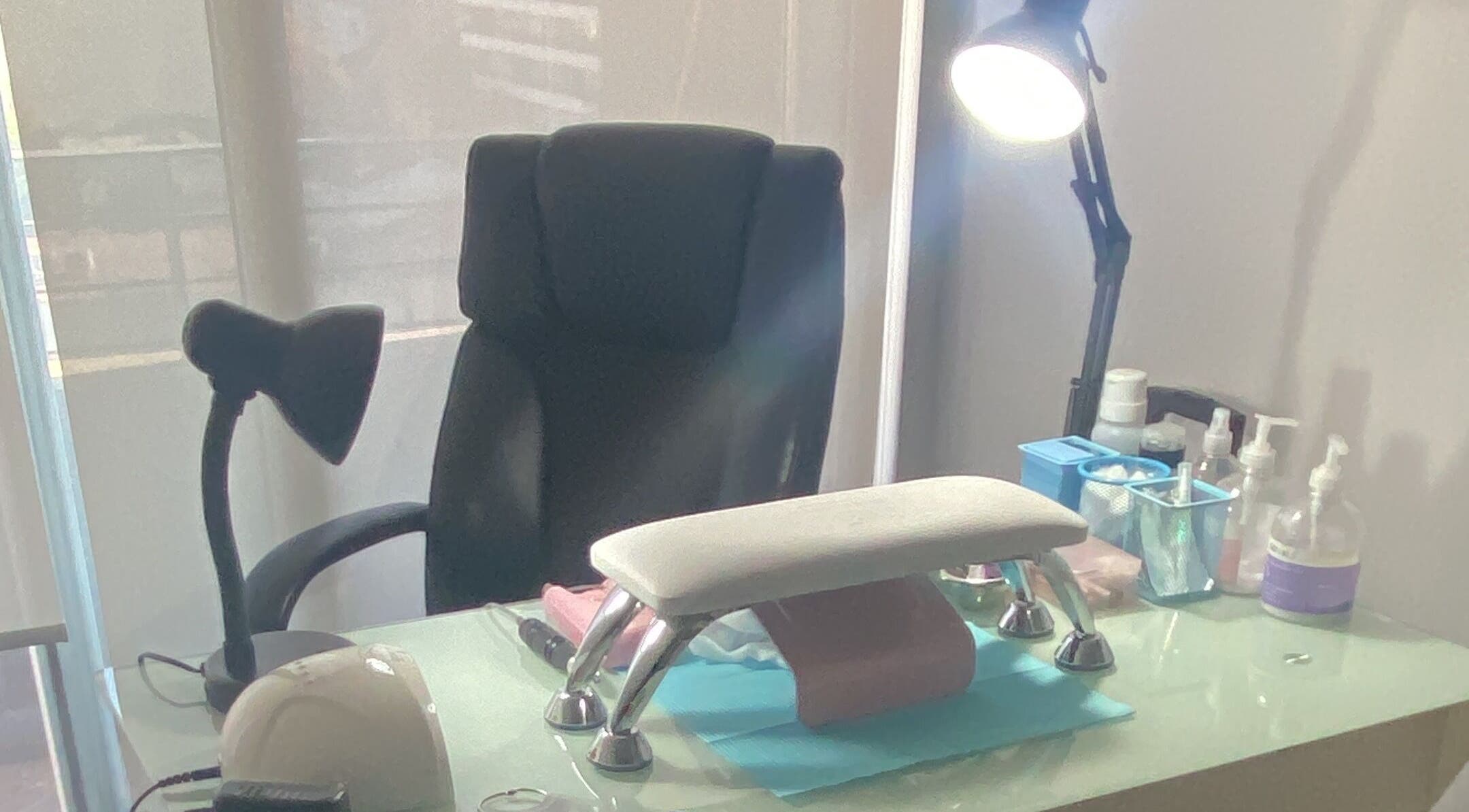 Zona de trabajo en Glowesome Nails, Santiago, Región Metropolitana, CL, con silla y mesa equipada para manicura.