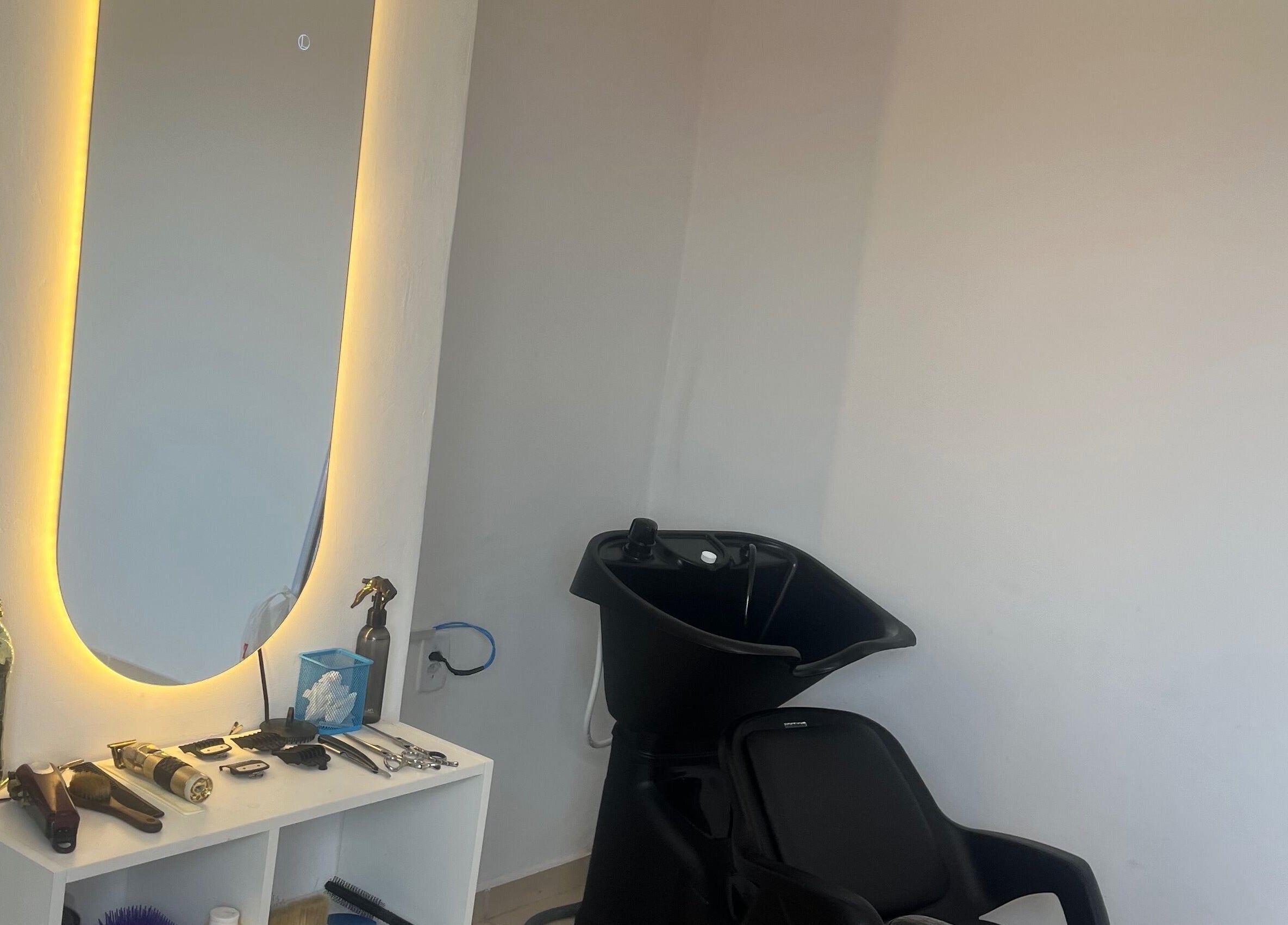 Estação de beleza moderna na RaphabarberShop, Maranhão, Maranhão, BR com lavatório e espelho iluminado.