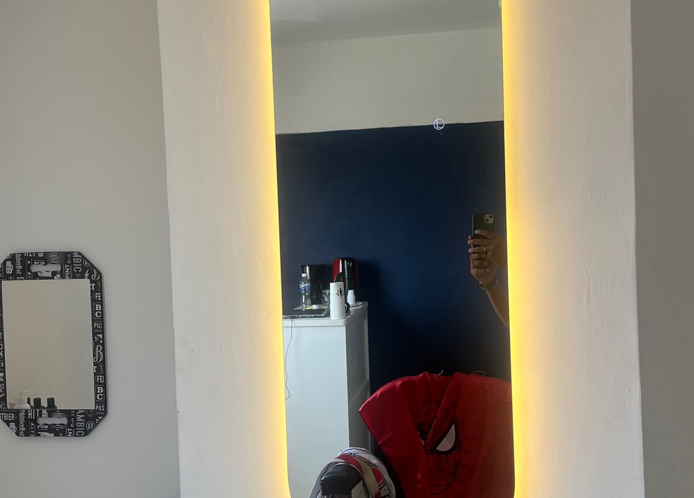 Espelho iluminado na RaphabarberShop em Maranhão, Maranhão, BR, refletindo parte de um interior moderno.