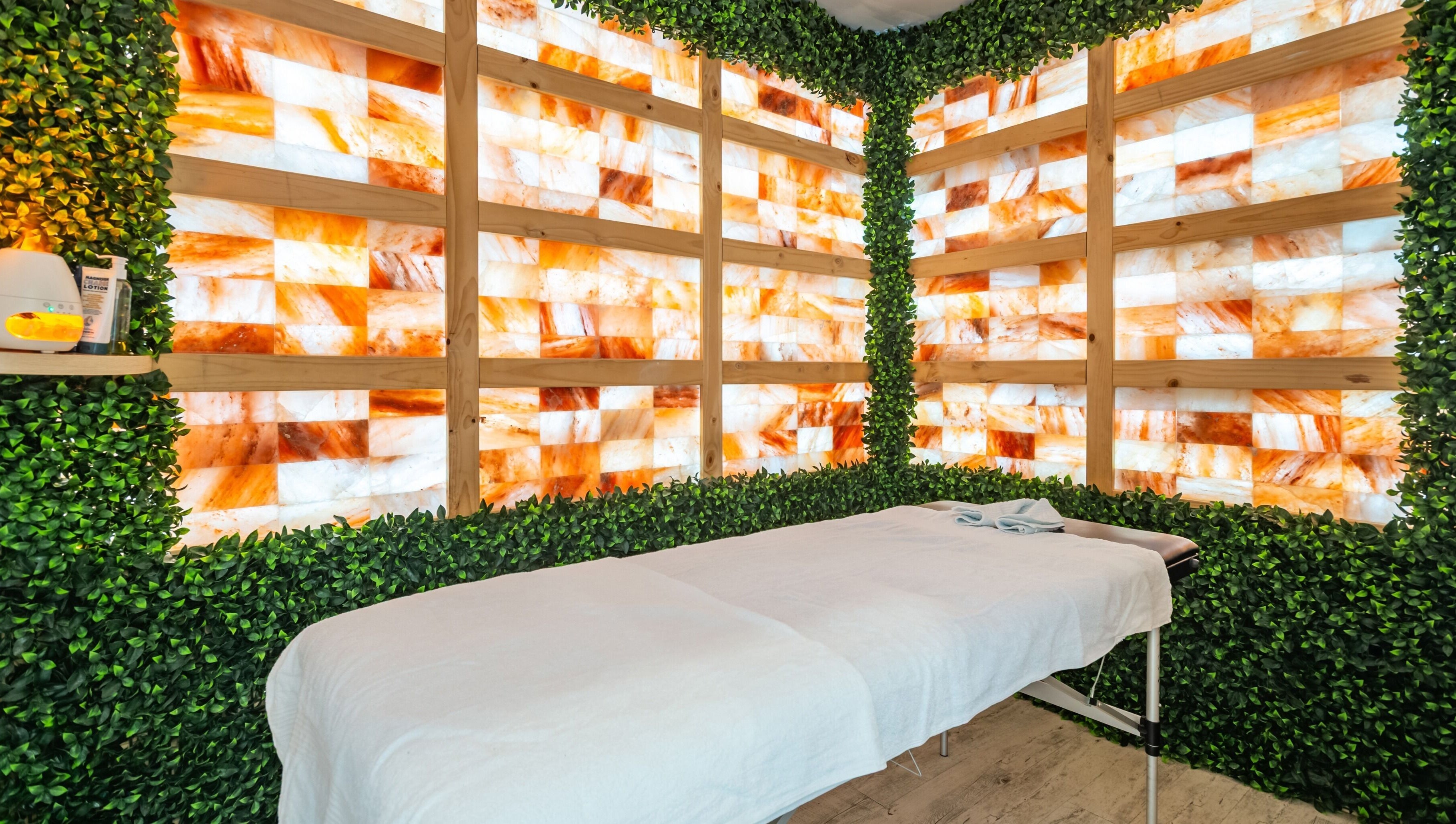 Tranquil massage room at Halo Sanctuary in Ramsgate, New South Wales, AU with Himalayan salt wall and greenery.