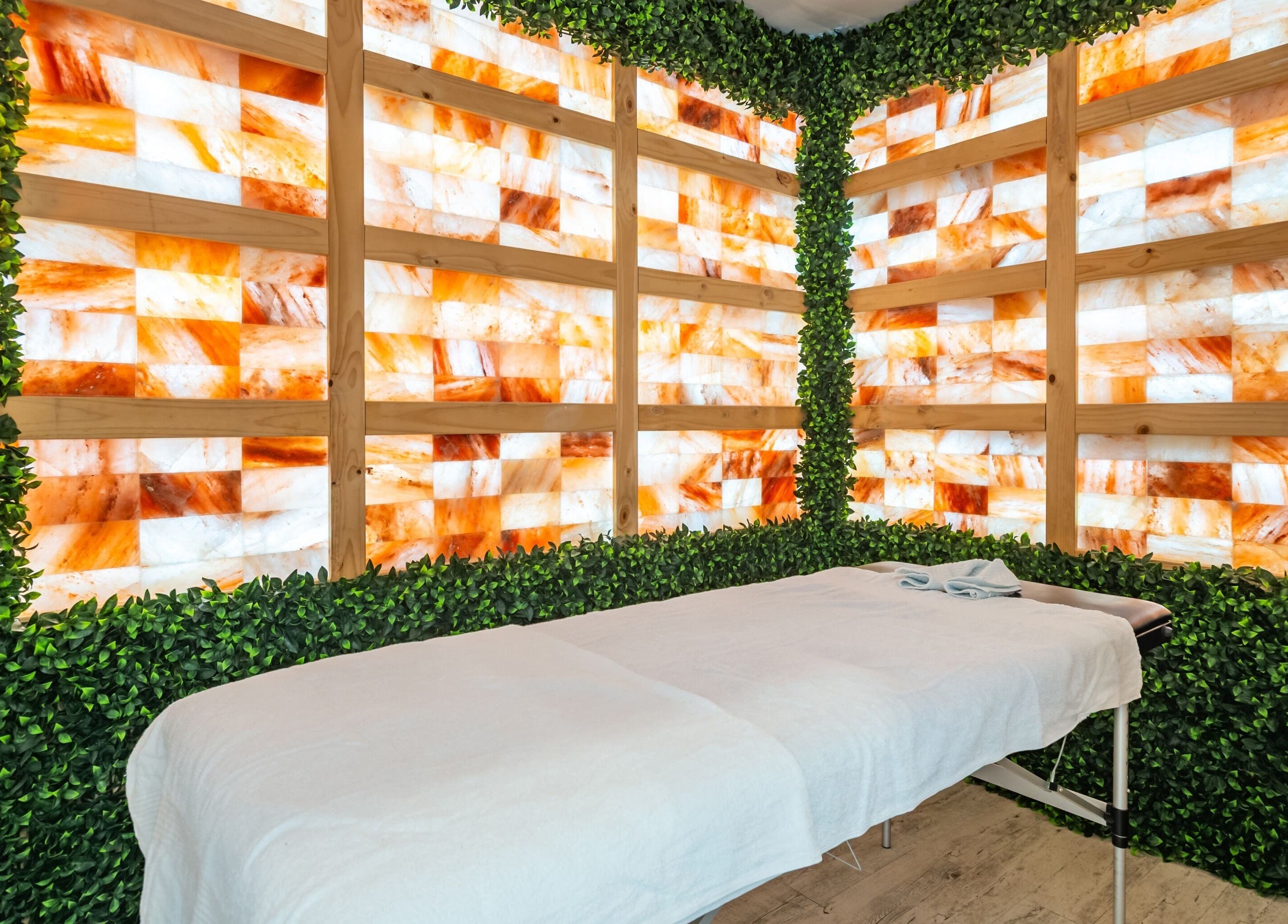 Tranquil massage room at Halo Sanctuary in Ramsgate, New South Wales, AU with Himalayan salt wall and greenery.