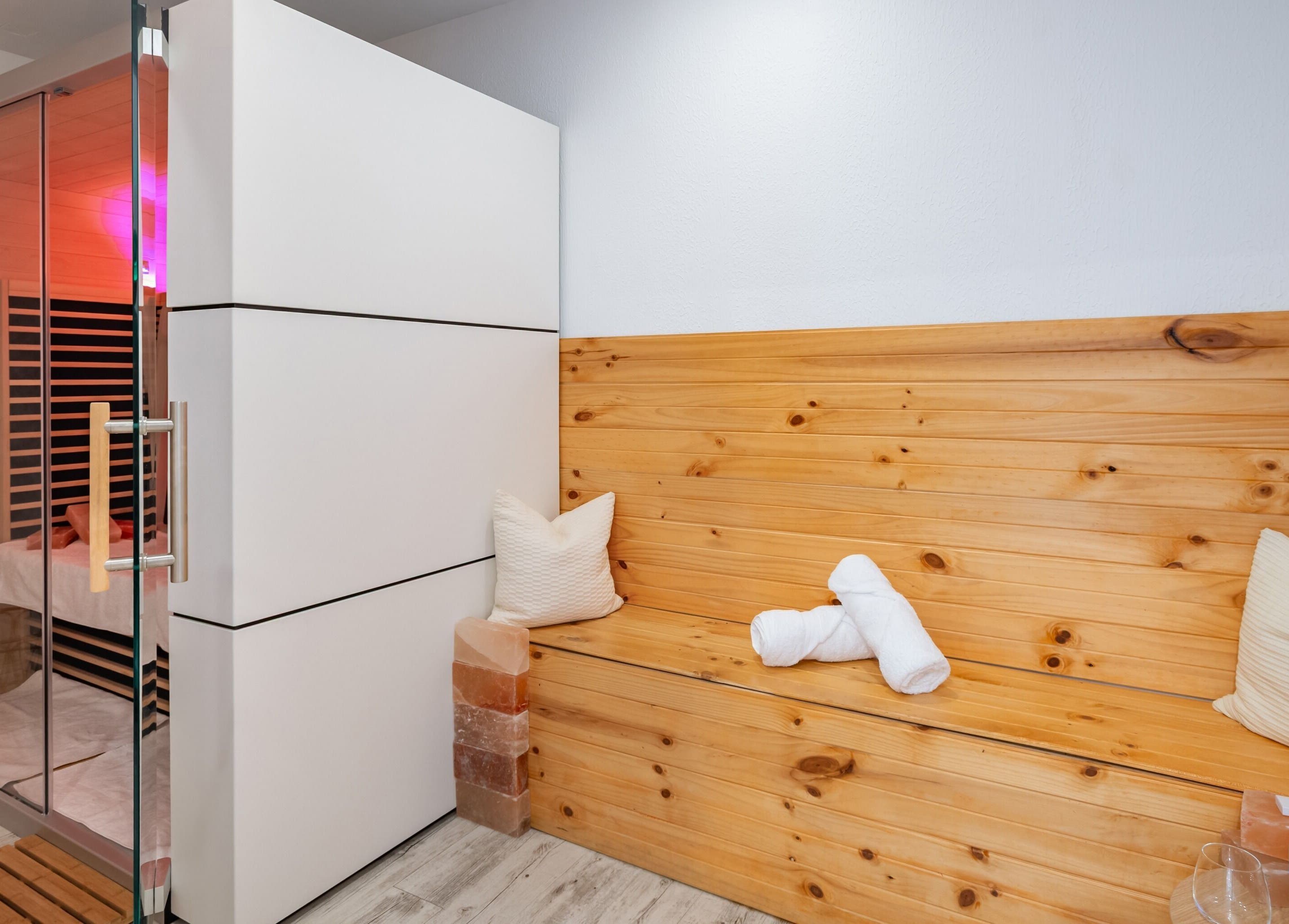 Relaxing sauna at Halo Sanctuary, Ramsgate, New South Wales, AU with wooden bench and soft lighting.