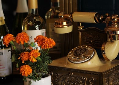 Teléfono retro con flores y vino en El Congal, Ciudad De México, Ciudad De México, MX.