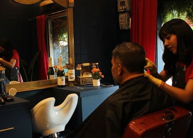 Estilista en El Congal, Ciudad De México, ofrece corte de cabello en un elegante salón.