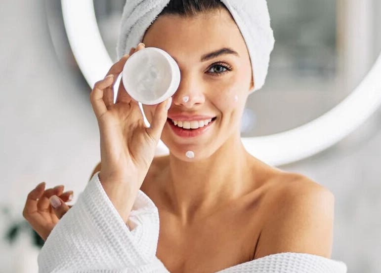 Smiling woman with face cream at Realm of Beauty by Lour, Springwood, Queensland, AU.