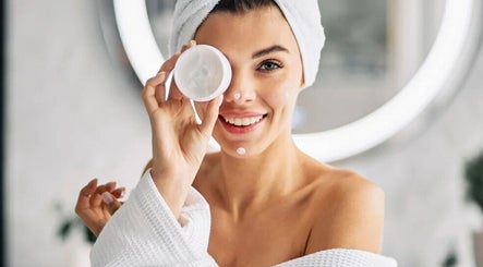 Smiling woman with face cream at Realm of Beauty by Lour, Springwood, Queensland, AU.