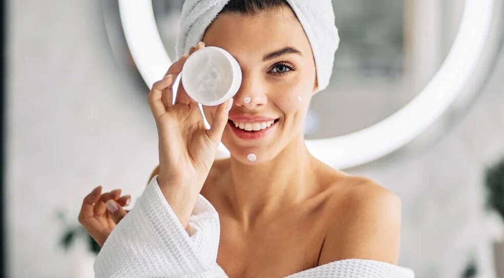 Smiling woman with face cream at Realm of Beauty by Lour, Springwood, Queensland, AU.