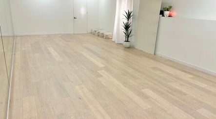 Spacious yoga studio at Fia Yoga & Pilates in Melbourne, Victoria, AU, featuring wooden floors and plants.