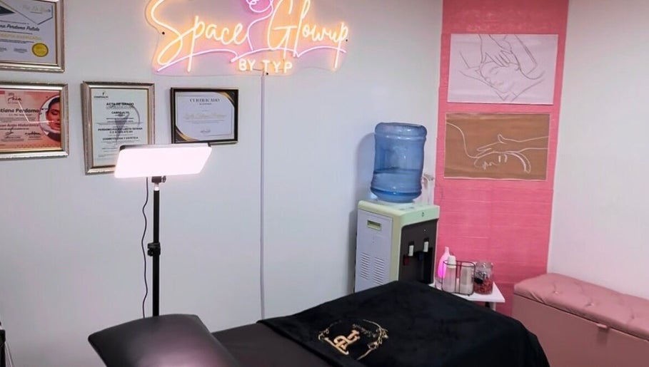 Sala de tratamiento en SpaceGlowup✨, Bogotá, con decoraciones artísticas y diplomas de certificación.