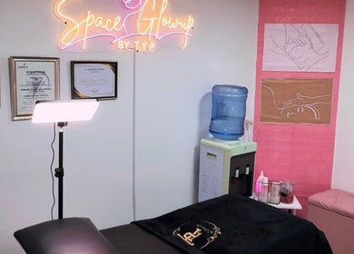 Sala de tratamiento en SpaceGlowup✨, Bogotá, con decoraciones artísticas y diplomas de certificación.
