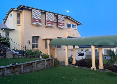 Charming exterior of Estelle Beauty - On The Range, Queensland, AU, with greenery and stonework.