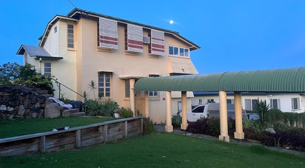 Charming exterior of Estelle Beauty - On The Range, Queensland, AU, with greenery and stonework.