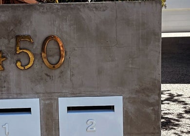 Entrance of Palm Beach Glow at 450 Palm Beach, Queensland, AU with modern golden address numbers.
