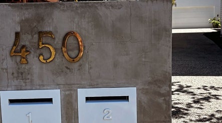 Entrance of Palm Beach Glow at 450 Palm Beach, Queensland, AU with modern golden address numbers.