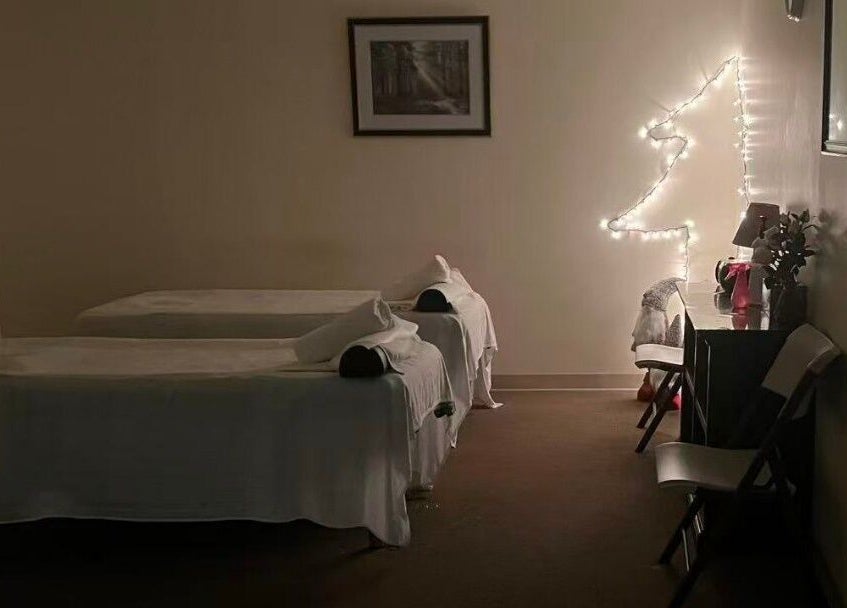 Peaceful massage room at Acupressure Spa, Burke, Virginia, US, featuring two beds with soft lighting.