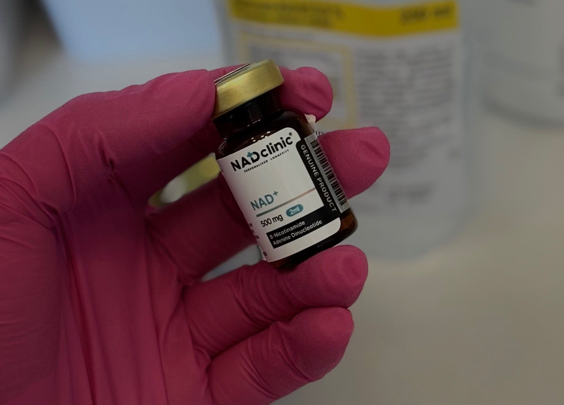 Rózsaszín kesztyűs kéz tart üvegcsét a DoktorHáz Perfect Look-ban, Budapest, Magyar, HU.