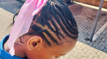Close-up of a child's braided hairstyle with pink ribbon at Kempton Park, Gauteng, ZA.
