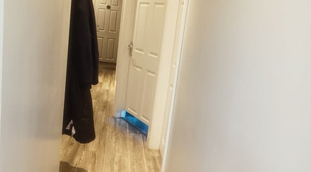 Bright hallway at Physical Therapy in Greenford, England, GB with wooden floors and white doors.