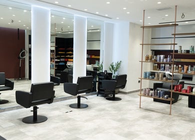 Modern salon at MIER BEAUTY LOUNGE in Abu Dhabi, AE with sleek chairs and product shelves.